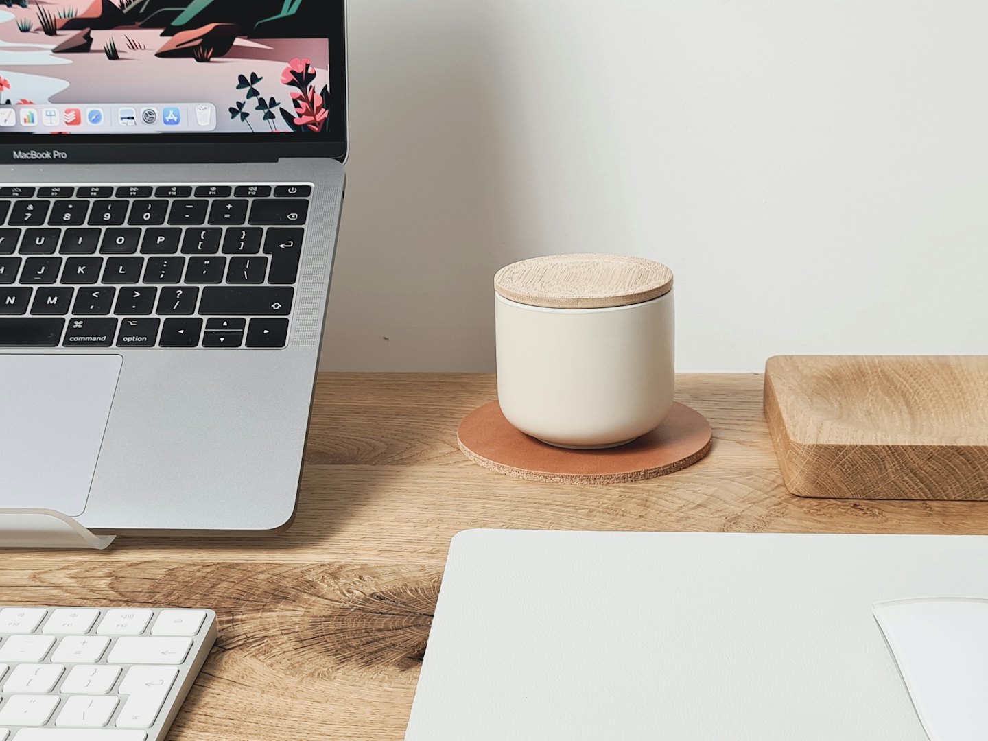 Laptop displaying illustration on a clean, minimalist desk.